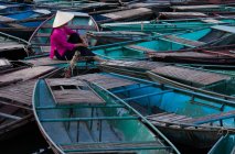 Woman sits amidst a raft of boats — Stock Photo