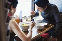 Man and woman eating noodles — Stock Photo