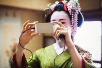 Traditionelle Geisha macht ein Selfie. — Stockfoto