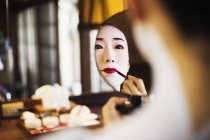 Geisha or maiko with a hair and make up artist — Stock Photo