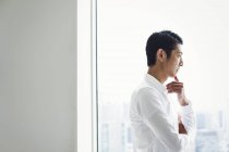 Homme d'affaires dans le bureau debout près de la fenêtre — Photo de stock