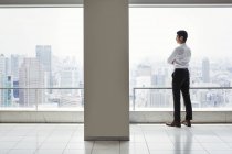 Homme d'affaires dans le bureau debout près de la fenêtre — Photo de stock