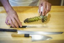 Chef grating horseardish root for wasabi. — Stock Photo