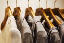 Row of clothes on wooden hangers — Stock Photo