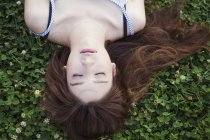 Жінка з довгим волоссям лежить на газоні . — стокове фото