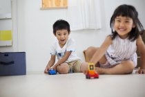 Діти грають з іграшками на підлозі . — стокове фото