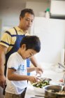 Mann bereitet mit seinem Sohn ein Essen zu. — Stockfoto