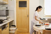 Mujer preparando una comida en una cocina - foto de stock
