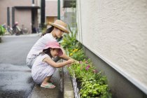Woman and her daughter tending plants — Stock Photo