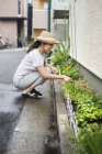Frau duckt sich und pflanzt Blumen — Stockfoto