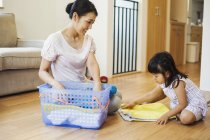 Woman and daughter folding clean laundry. — Stock Photo