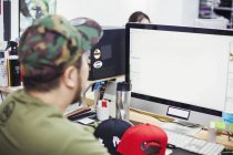 Homme assis à un bureau à l'aide d'un ordinateur — Photo de stock