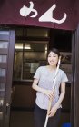 Woman standing by the door of noodle shop — Stock Photo