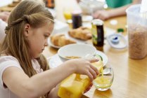 Girl pouring orange juice — Stock Photo
