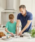 Hombre y joven en la cocina - foto de stock