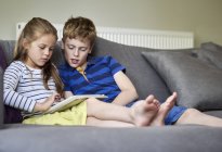 Zwei Kinder teilen sich digitales Tablet — Stockfoto