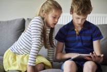 Двое детей делятся цифровым планшетом — стоковое фото