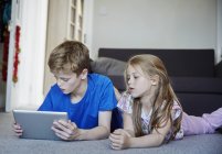 Двоє дітей діляться цифровим планшетом — стокове фото