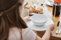 Mädchen deckt den Tisch zum Frühstück — Stockfoto