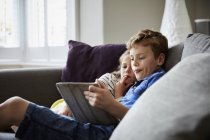 Children seated sharing a digital tablet — Stock Photo