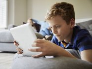 Мальчик смотрит цифровой планшет — стоковое фото