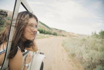 Frau lehnt sich aus fahrendem Jeep — Stockfoto