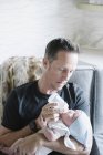 Père berçant un petit bébé — Photo de stock