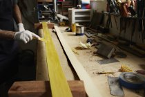 Uomo esaminando pezzo di legno — Foto stock
