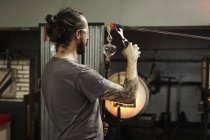 Soffiatore di vetro che lavora su un pezzo di vetro — Foto stock