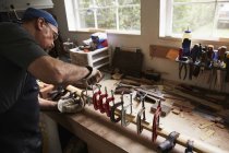 Mann arbeitet in Werkstatt an Holzbogen — Stockfoto