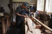 Людина працює над дерев'яним бантом — стокове фото