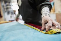 Жінка вимірює оббивку тканини — стокове фото