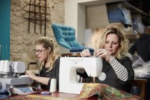 Mulheres trabalharam sentadas com máquinas de costura — Fotografia de Stock