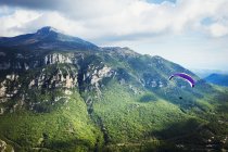 Paraglider in flight over valley — Stock Photo