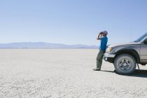 Hombre de pie en el vasto desierto - foto de stock