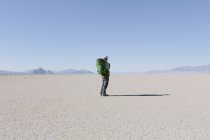 Mochilero senderismo masculino en el vasto desierto - foto de stock