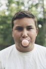 Мальчик надувает пузырь жвачки — стоковое фото