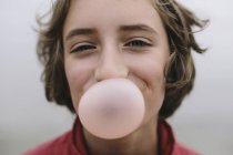Девушка надувает пузырь жвачки — стоковое фото