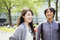 Japanese man and woman standing in park — Stock Photo