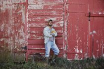 Young man standing near barn — Stock Photo