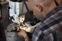 Homem trabalhando na máquina de costura industriall — Fotografia de Stock