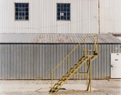Лестница рядом с промышленным блоком — стоковое фото