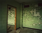 Комната с шелушащейся зеленой краской — стоковое фото