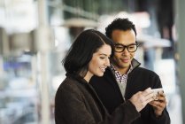 Man and woman holding cellphone — Stock Photo