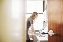 Woman standing and using laptop — Stock Photo