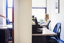 Frau sitzt am Schreibtisch im Büro — Stockfoto