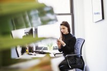 Woman sitting at desk in office — Stock Photo