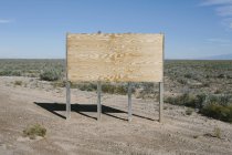 Blank billboard in desert — Stock Photo