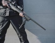 Hombre sosteniendo rifle de francotirador de alta potencia - foto de stock
