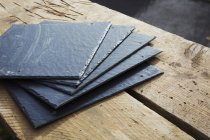 Slate tiles on a wooden surface — Stock Photo